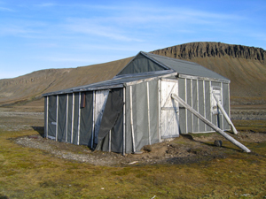 Heimland på Barentsøya, ei såkalt Merckollhytte. Steinbeisfjellet i bakgrunnen.